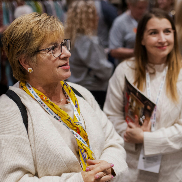 woman speaking to someone at a booth during a Conference